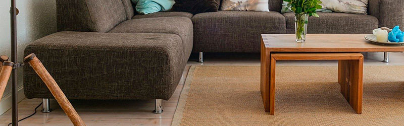 sala de estar com jogo de sofás na cor marrom e pés de alumínio